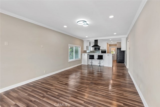 unfurnished living room with ornamental molding and dark hardwood / wood-style floors