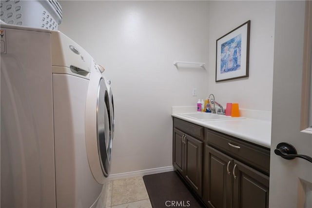 laundry area featuring cabinets, light tile patterned floors, separate washer and dryer, and sink