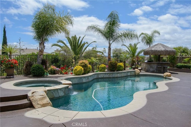 view of pool with an in ground hot tub, pool water feature, and an outdoor bar