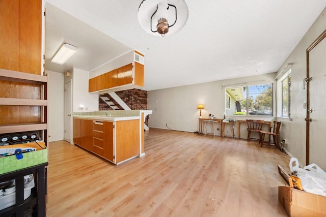 kitchen with kitchen peninsula and light hardwood / wood-style flooring