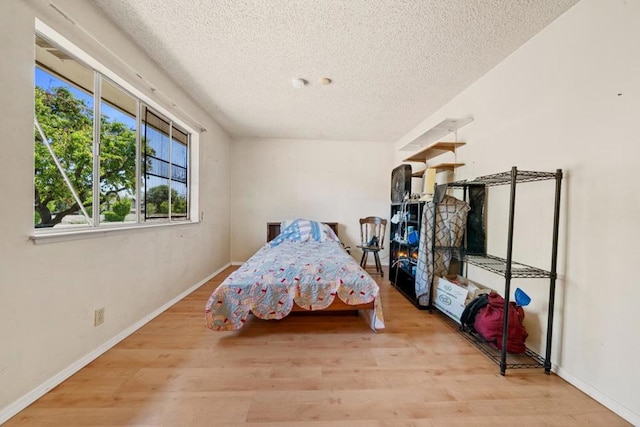 bedroom with light hardwood / wood-style flooring and a textured ceiling