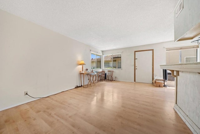 unfurnished living room featuring a textured ceiling and light hardwood / wood-style flooring