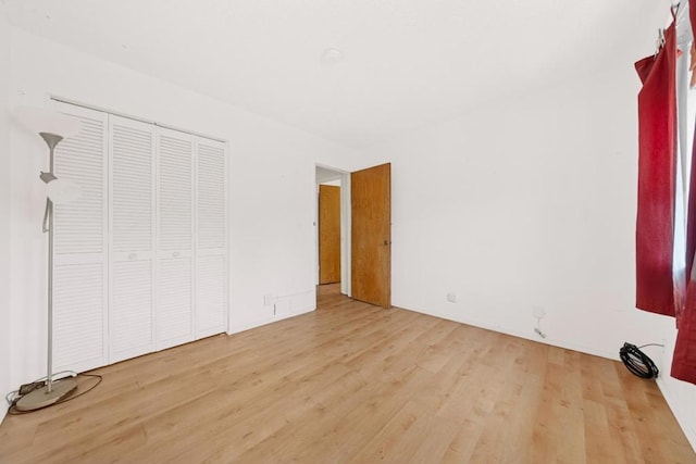 unfurnished bedroom featuring a closet and light wood-type flooring