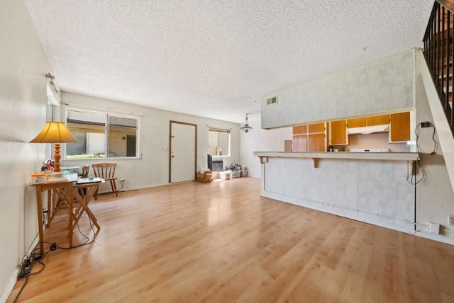 living room featuring a textured ceiling and light wood-type flooring