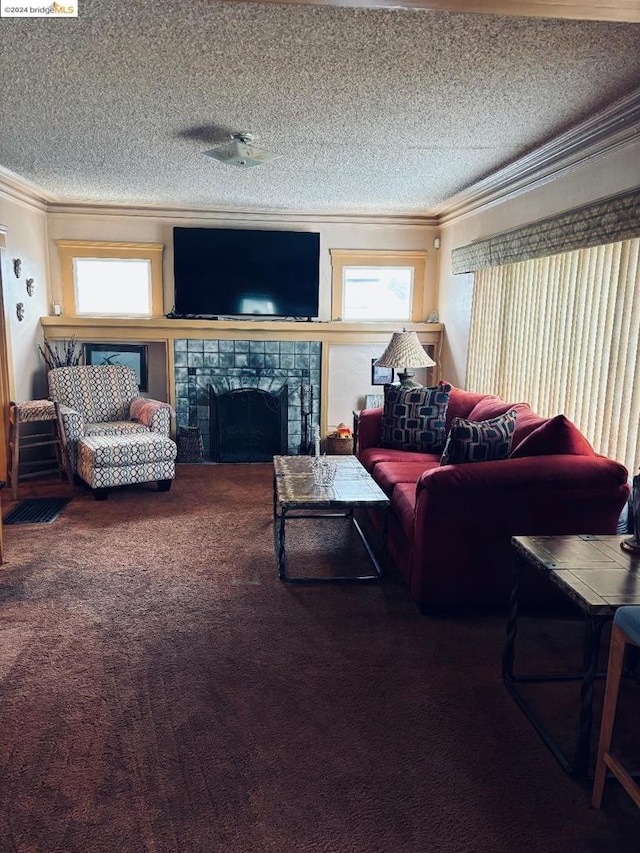 living room with carpet, ornamental molding, a tile fireplace, and a textured ceiling