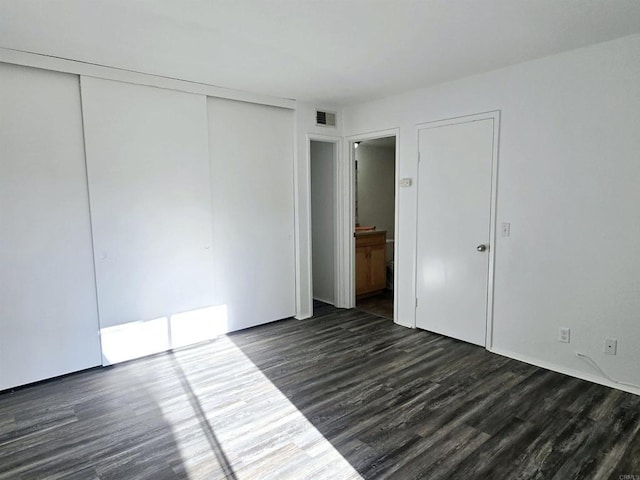 unfurnished bedroom featuring dark hardwood / wood-style flooring