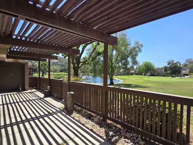 wooden deck with a yard, a water view, and a pergola