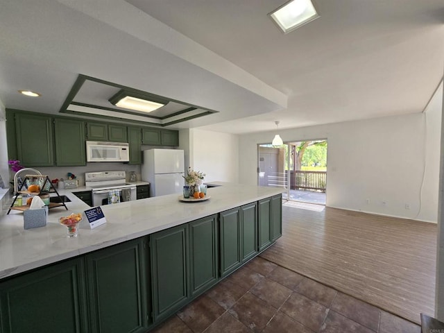 kitchen with white appliances, green cabinets, sink, kitchen peninsula, and a tray ceiling