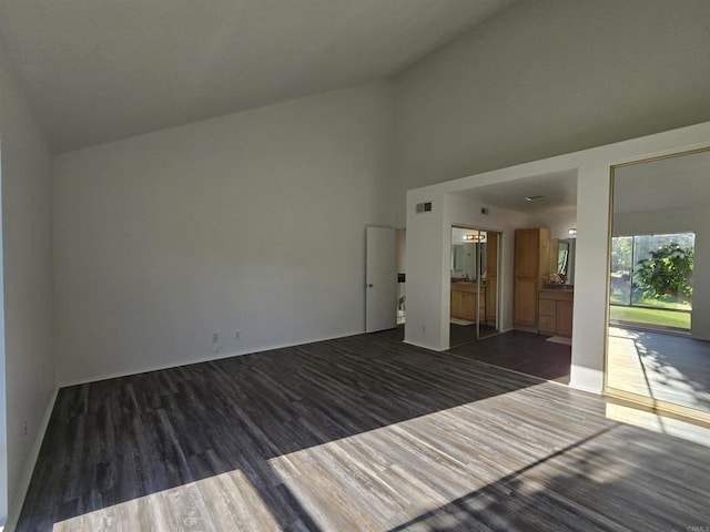 unfurnished room with high vaulted ceiling and dark hardwood / wood-style flooring