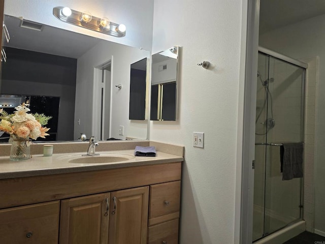 bathroom featuring walk in shower and vanity