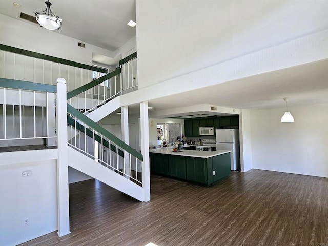 kitchen featuring decorative light fixtures, dark hardwood / wood-style floors, and white appliances