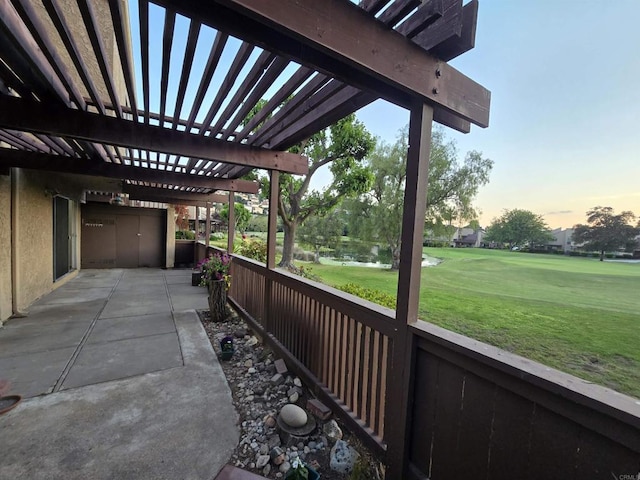 patio terrace at dusk featuring a lawn and a pergola