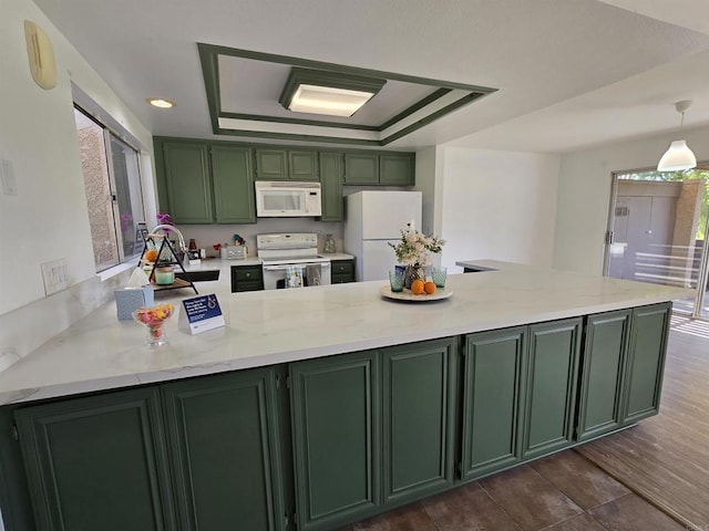 kitchen featuring kitchen peninsula, a tray ceiling, white appliances, green cabinetry, and light stone counters