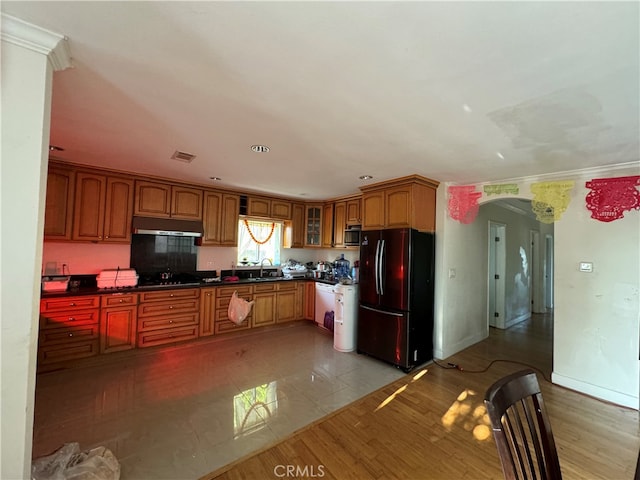 kitchen featuring light tile floors, sink, and black refrigerator