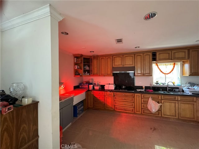 kitchen with built in desk, sink, gas stovetop, and dark tile floors