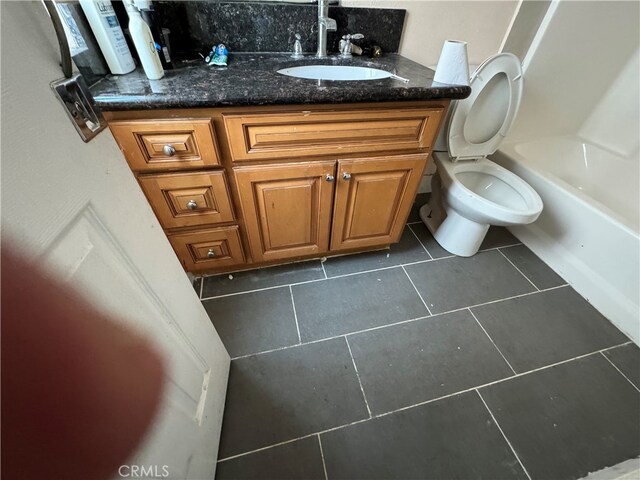 bathroom with tile floors, toilet, and vanity