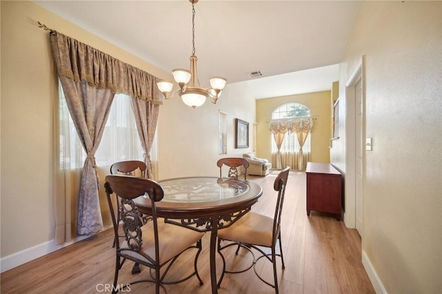 dining area featuring light hardwood / wood-style flooring and a notable chandelier