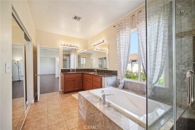 bathroom with tile patterned floors, vanity, and shower with separate bathtub