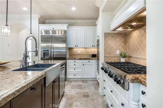 kitchen featuring ornamental molding, custom range hood, stone finish floor, stainless steel gas stovetop, and white cabinetry