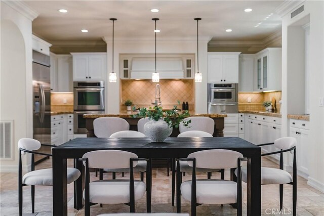 dining room featuring ornamental molding and sink