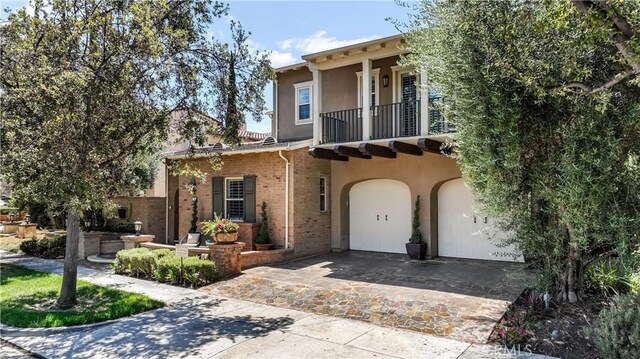 view of front of home featuring a garage and a balcony