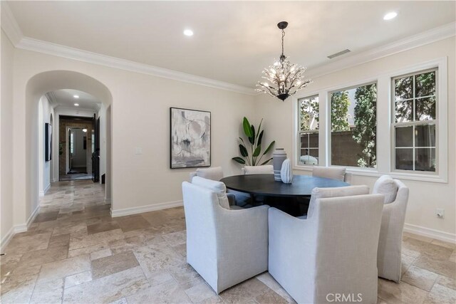 dining area featuring ornamental molding and an inviting chandelier