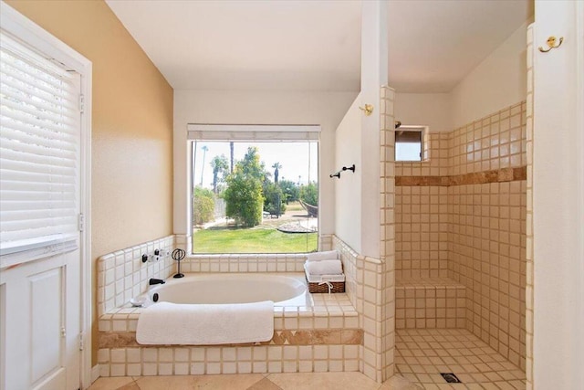 bathroom with shower with separate bathtub and tile floors