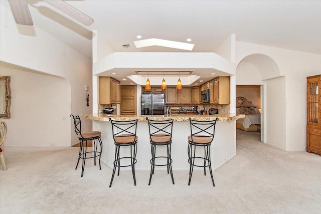 kitchen featuring hanging light fixtures, appliances with stainless steel finishes, light carpet, and backsplash