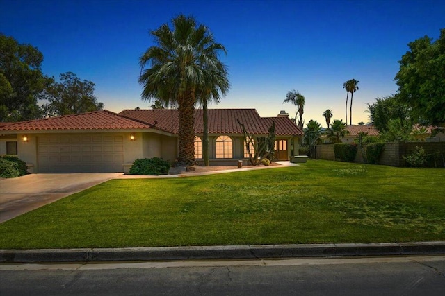 view of front of property with a garage and a lawn