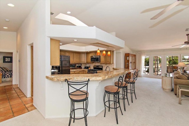 kitchen featuring appliances with stainless steel finishes, kitchen peninsula, backsplash, light tile flooring, and ceiling fan