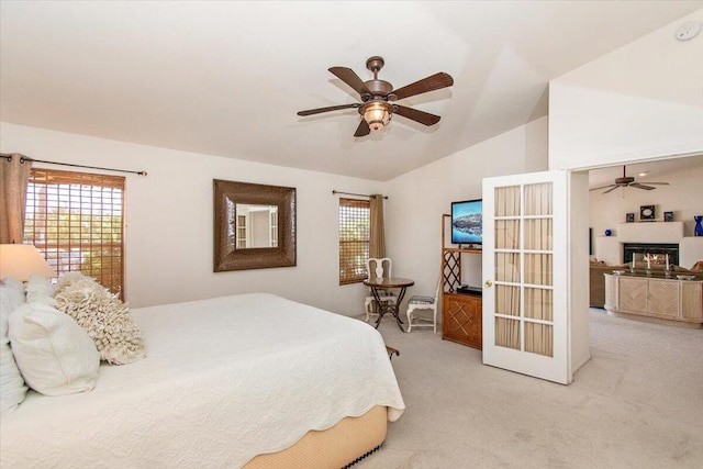 carpeted bedroom with lofted ceiling, ceiling fan, and multiple windows