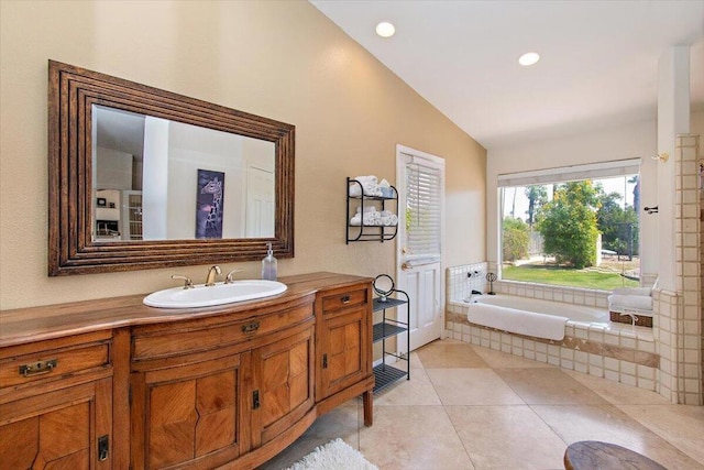 bathroom with tiled tub, vanity, tile floors, and lofted ceiling