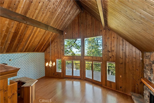 unfurnished living room featuring a wealth of natural light, beamed ceiling, high vaulted ceiling, and light wood-type flooring