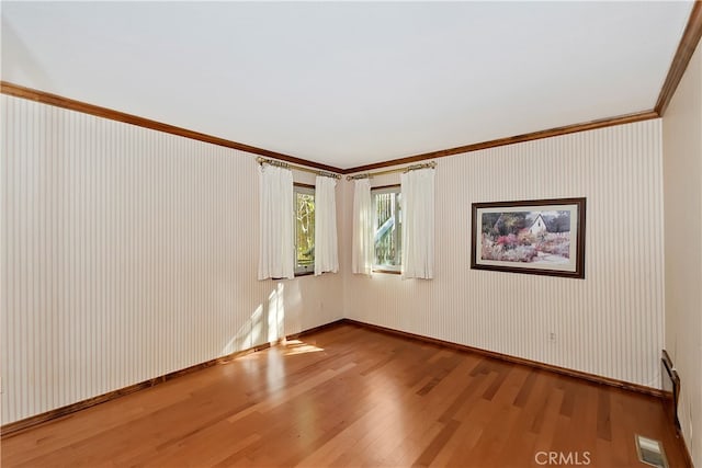 unfurnished room with ornamental molding and hardwood / wood-style flooring