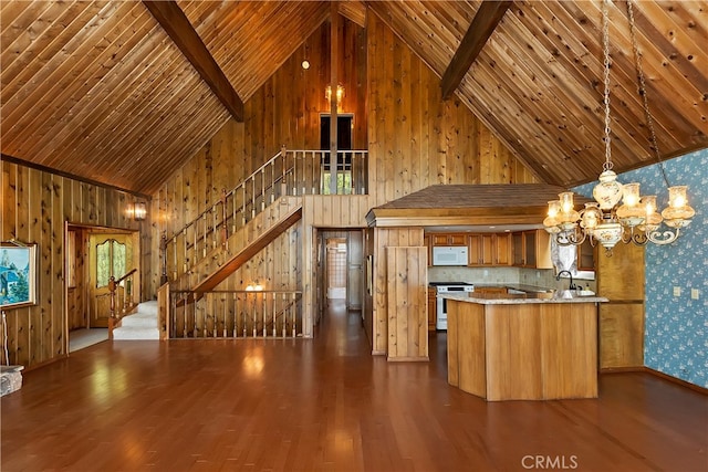 kitchen featuring white appliances, high vaulted ceiling, dark hardwood / wood-style flooring, kitchen peninsula, and a notable chandelier