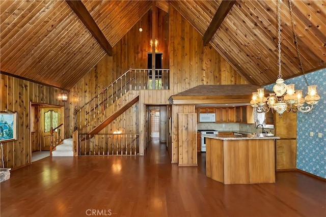 unfurnished living room with an inviting chandelier, sink, and dark hardwood / wood-style floors