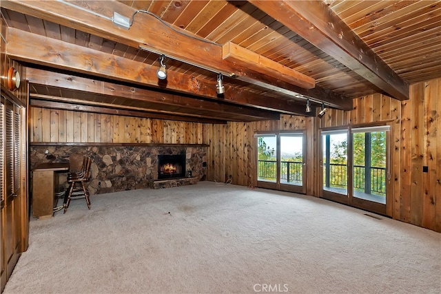 unfurnished living room featuring light carpet, wood walls, and beam ceiling