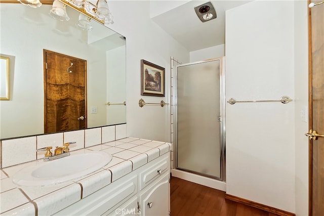 bathroom featuring vanity, a shower with shower door, and wood-type flooring