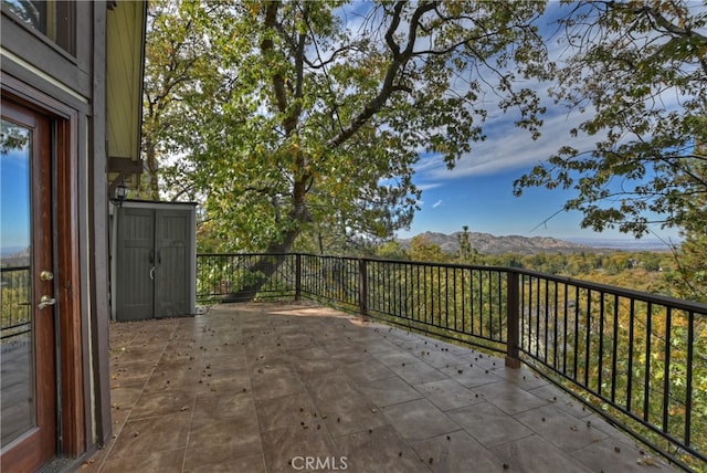 view of patio with a mountain view and a balcony