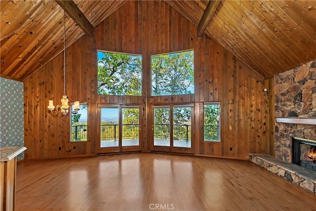 unfurnished living room with light hardwood / wood-style floors, beamed ceiling, high vaulted ceiling, and plenty of natural light