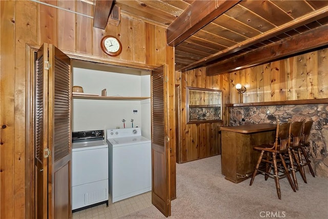 washroom with carpet, laundry area, wooden walls, and separate washer and dryer