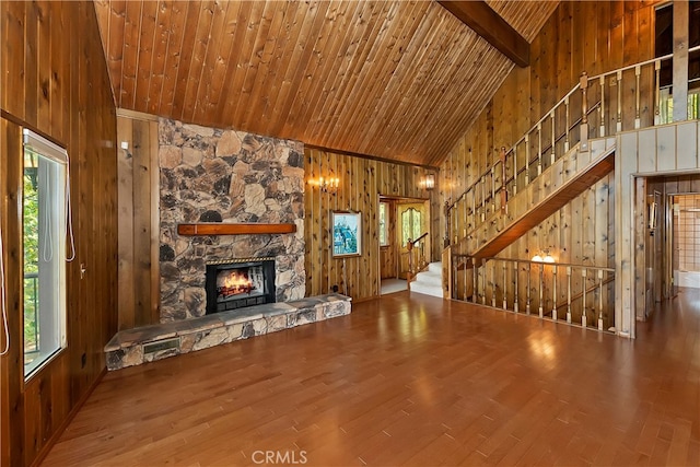 unfurnished living room featuring high vaulted ceiling, a healthy amount of sunlight, wood ceiling, and hardwood / wood-style floors