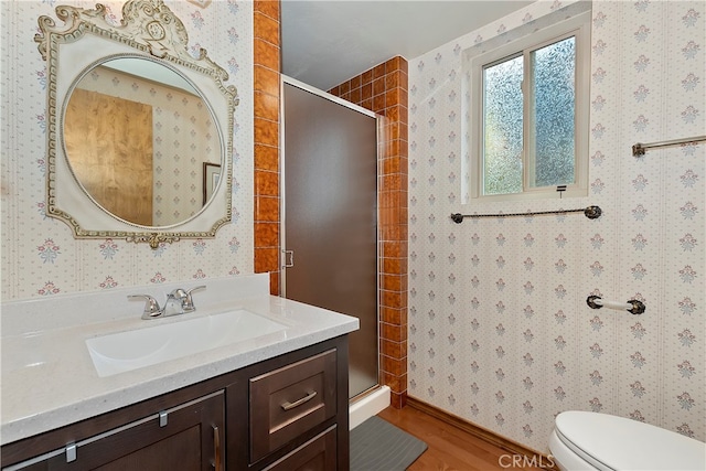 bathroom featuring a shower with door, vanity, wood-type flooring, and toilet