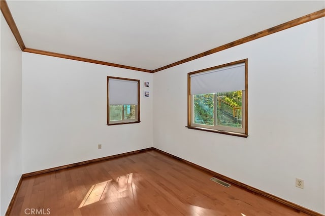 unfurnished room with crown molding and hardwood / wood-style floors