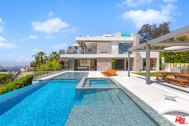 view of swimming pool with a patio and an in ground hot tub