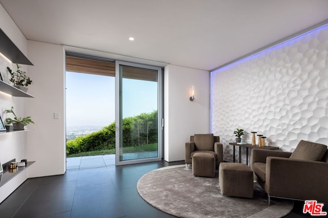 tiled living room featuring a wall of windows