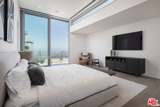 bedroom with wood-type flooring and expansive windows