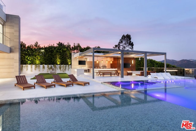 pool at dusk featuring a patio area