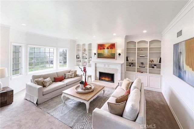 living room with built in shelves, light colored carpet, ornamental molding, and a high end fireplace