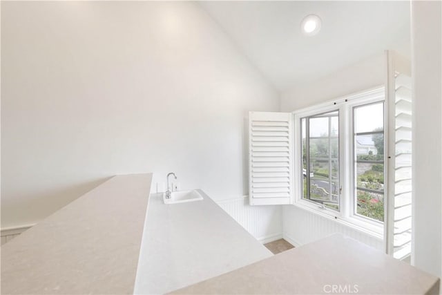 bathroom with sink and high vaulted ceiling